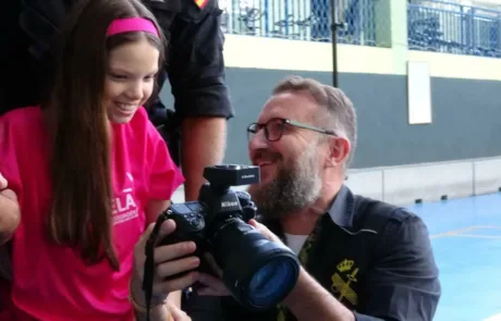 Carolina, en t-shirt ELA, regarde avec le photographe les images du calendrier sur l’écran de l’appareil.