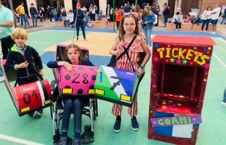 Concours de déguisements au collège COAMI : Carolina et ses frères et sœurs avec leurs autos tamponneuses en carton et la billetterie.