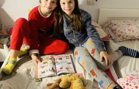 Isabel et son amie Martina, illustratrice du livre, feuillettent un catalogue assises sur le lit.