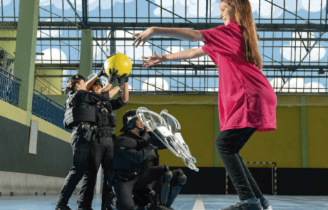 Photographie du calendrier ELA 2024 : Carolina lance un ballon à des agents de la Guardia Civil dans un gymnase.