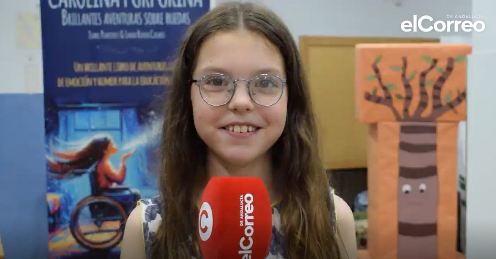 Isabel, lunettes rondes, répond au micro d’elCorreo de Andalucía, à côté du kakémono du livre.