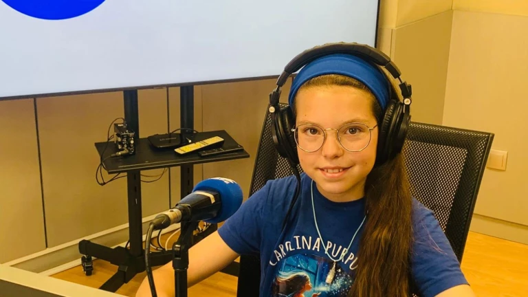 Isabel, casque sur les oreilles et t-shirt « Carolina Purpurina », sourit devant le micro d’un studio de radio.