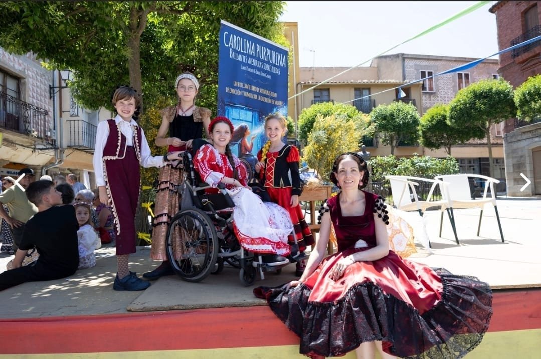Sur une estrade, des enfants en costumes d’époque devant le kakémono du livre ; l’une est en fauteuil roulant, une autre souffle des paillettes.