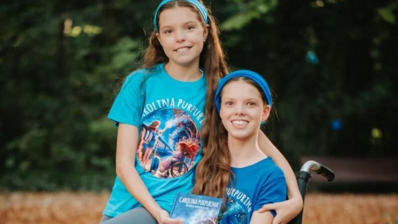 Isabel et Carolina, en t-shirts Carolina Purpurina, tiennent le livre dans un parc.