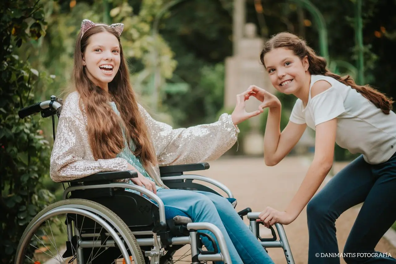Carolina et Isabel forment un cœur avec leurs mains dans un parc.