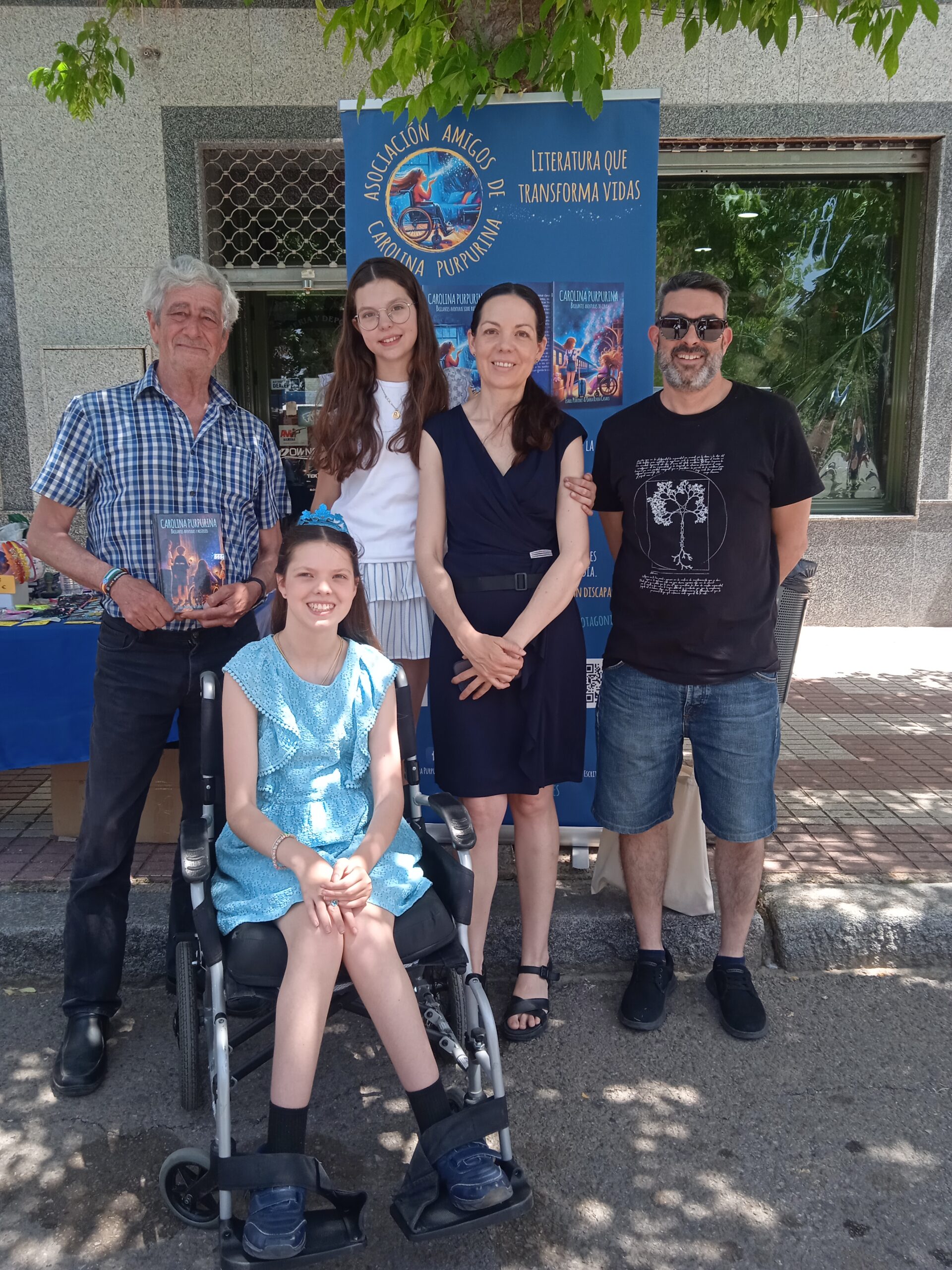 Présentation du livre : la famille pose devant le kakémono de l’Asociación Amigos de Carolina Purpurina.