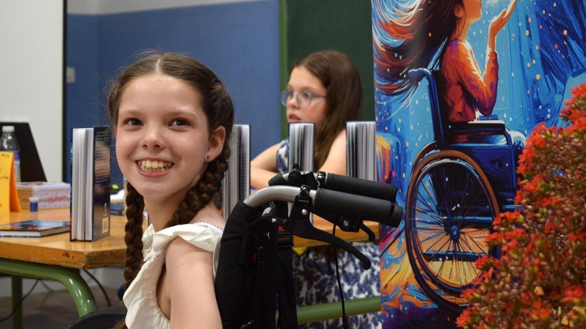 Présentation du livre : Carolina sourit dans son fauteuil roulant près du kakémono de la couverture ; derrière, une fillette assise à la table de livres.